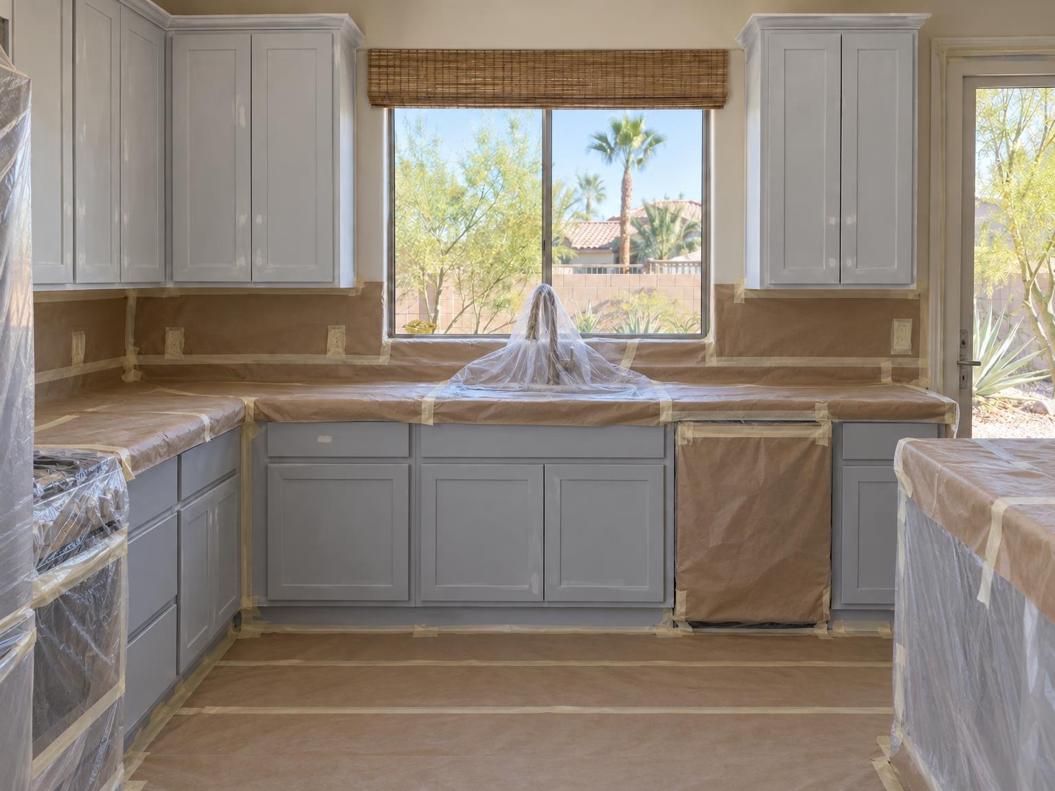 A kitchen masked and primed mid-job