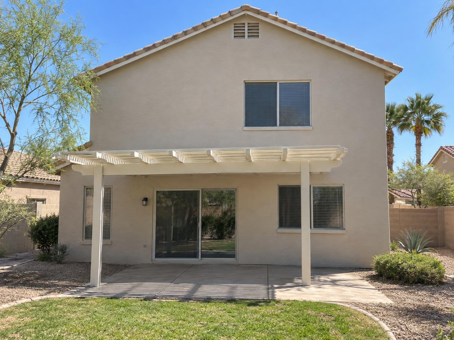 The same house after painting, with a white pergola