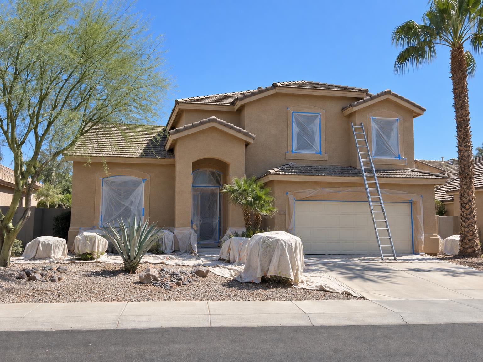 Two-story stucco home mid-job with a ladder up